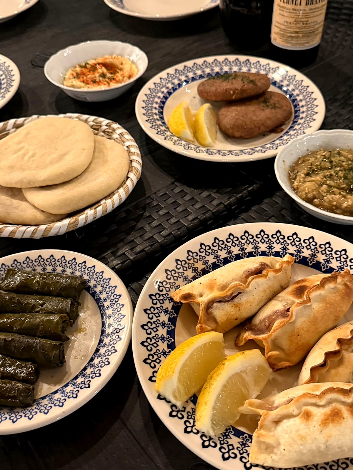 Mesa servida en Fagú: sfijas, kipes, niños en hoja de parra, hummus y pan árabe
